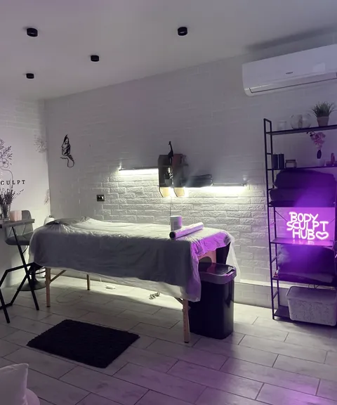 Кабінет із кушеткою і неоновим написом BodySculpt Hub